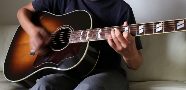 アコースティックギターを弾いている画像です。